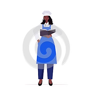 Female cook in uniform african american woman chef holding recipe book cooking food industry concept