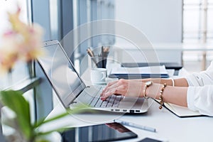 Female copywriter at her workplace, home, writing new text using laptop and Wi-Fi internet connection in the morning. photo