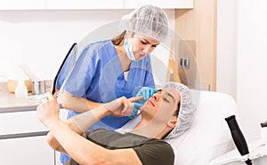 Female cosmetician consulting man before facial treatment