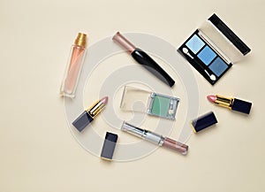 Female cosmetics for make-up layout on a pastel background. Cosmetic shadows, make-up brush, eyeshadow lipstick, perfume bottle.