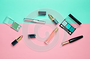 Female cosmetics for make-up layout on a pastel background. Cosmetic shadows, make-up brush, eyeshadow lipstick, perfume bottle.