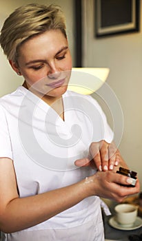 Female cosmetologist applying facial cream in salon