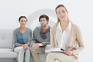 Female counselor with young couple in background photo