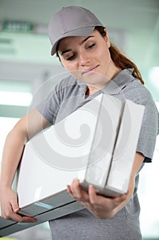 female courier carrying two long boxes