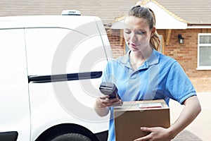 Female Courier Delivering Package To Domestic House