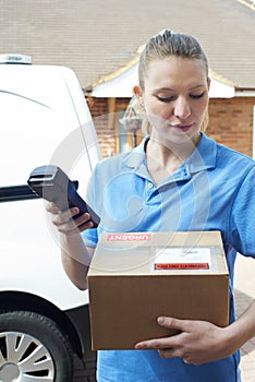 Female Courier Delivering Package To Domestic House