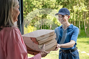 Female courier delivering pizza to client home.