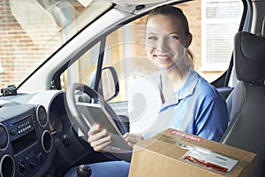 Portrait Of Female Courier In Van With Digital Tablet Delivering