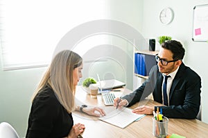 Female coworker checking work papers with a colleague