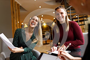 Female caucasian coworkers smiling in coworking meeting at office