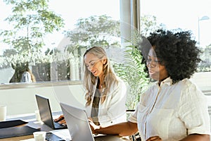 Female coworkers smiling while working together in the office