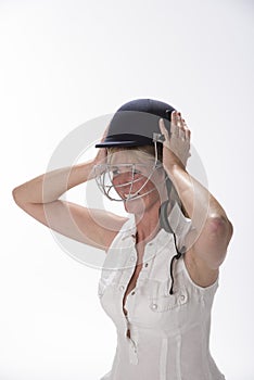 Female cricketer putting on safety helmet