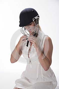 Female cricketer putting on safety helmet