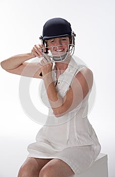 Female cricketer putting on safety helmet