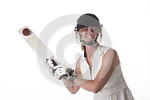 Female cricketer in safety helmet hitting a ball