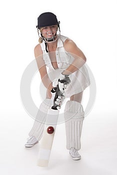 Female cricketer in a white dress with bat, pads, bat and safety helmet.