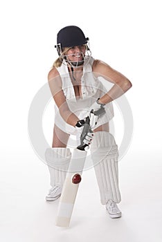 Female cricketer in a white dress with bat, pads, bat and safety helmet.