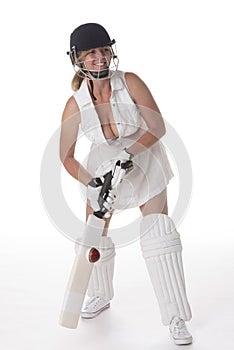 Female cricketer in a white dress with bat, pads, bat and safety helmet.