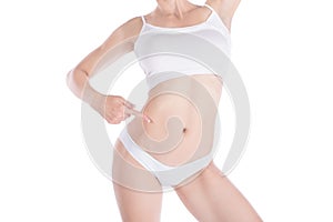 Female cropped fit slim body. Woman points to her slender waist with her finger. Isolated on white