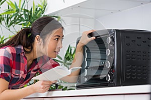 Female customer checking oven instructions