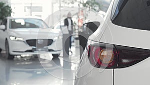 Female customer choosing automobile to buy at dealership salon