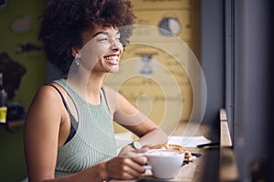 Female Customer In Coffee Shop Window Working Writing In Notebook 