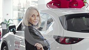 Female customer examining new automobile on sale at auto dealership