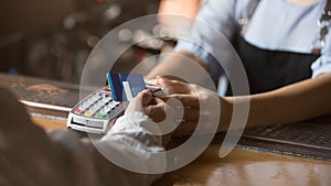 Female customer holding credit card near nfc technology on counter