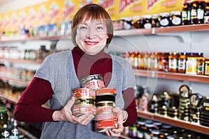 Female customer holding tin canned goods in store