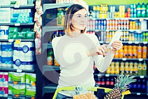 Female customer looking at notes in shopping list