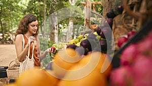 Female Customer At Market Stall Choosing Fresh Fruit And Vegetables