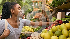 Female Customer At Market Stall Choosing Fresh Fruit And Vegetables