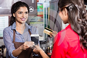 Female Customer paying for coffee with credit card