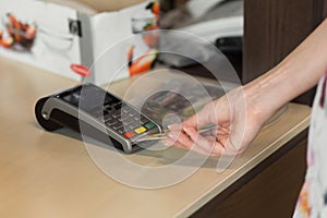 Female customer paying by credit card in cafe.