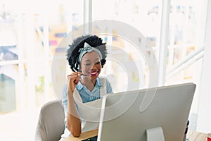 Female customer service executive talking on headset at desk in office