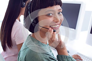 Female customer service executive working on computer at desk in office