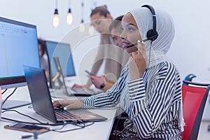 Female Customer Service Representative Answer Client`s Questions in a Headset. Multi-Ethnic Team of Specialists. Happy african