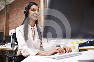 Female Customer Services Agent Working At Desk In Call Center photo