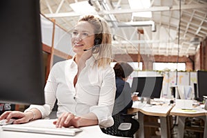 Female Customer Services Agent Working At Desk In Call Center photo