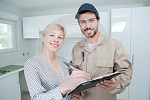 female customer signing tradesmans clipboard