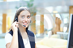 Female customer support operator with headset and smiling.