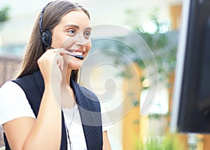 Female customer support operator with headset and smiling.