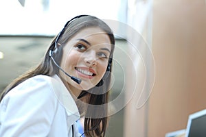 Female customer support operator with headset and smiling.