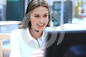 Female customer support operator with headset and smiling.