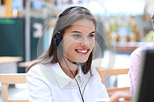 Female customer support operator with headset and smiling.