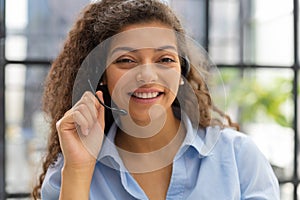 Female customer support operator with headset and smiling.