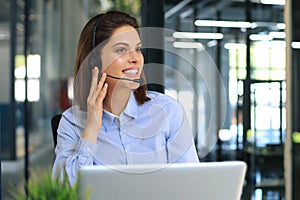 Female customer support operator with headset and smiling.