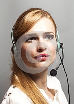 Female customer support operator with headset and smiling isolated on gray background