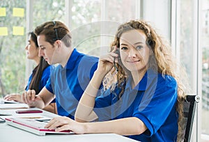 Female customer support operator at work. Team Business and Delivery call center in office. Working with a headset in blue uniform