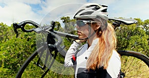 Female cyclist carrying bicycle on countryside road 4k